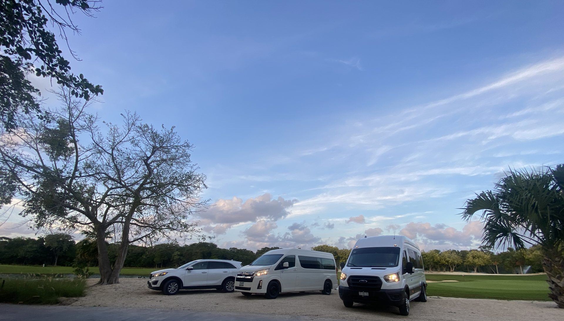 Tulum Private Tours fleet: Ford Transit, Toyota Hiace and Kia Sorento parked under a Riviera Maya sky